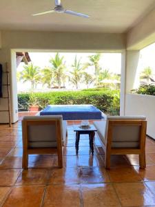- un salon avec deux chaises et une table dans l'établissement Villa Caracol in Las Palmas Luxury Villas, à Barra de Potosi