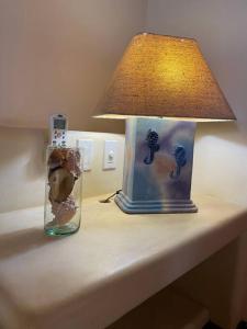 une lampe et un vase sur une table à côté d'une lampe gmaxwell gmaxwell gmaxwell dans l'établissement Villa Caracol in Las Palmas Luxury Villas, à Barra de Potosi