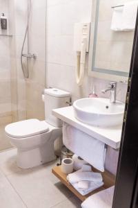 a white bathroom with a sink and a toilet at Hotel Balkan Centar in Bijeljina