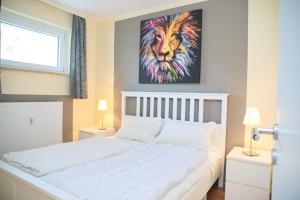 ein Schlafzimmer mit einem Bett mit einem Löwengemälde in der Unterkunft Fürstenhof Whg 108 inkl WLAN in Grömitz