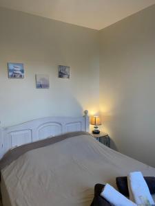 a bedroom with a bed and a lamp on a table at AD41 - La Perle Marine Jolie maison avec jardin et terrasse in Ault