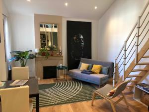 a living room with a blue couch and a fireplace at Cocons Avignon in Avignon