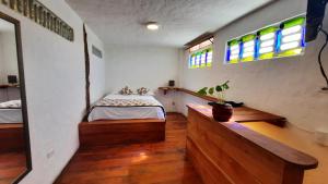 a bedroom with a bed and two windows at Alma de cedrela in Puerto Ayora