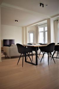 een woonkamer met een tafel en stoelen en een bank bij Luxury 2 Bedroom - Antwerp City Centre in Antwerpen