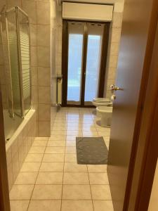 uma casa de banho com um WC, uma banheira e uma porta em Appartamento ONE em Novara