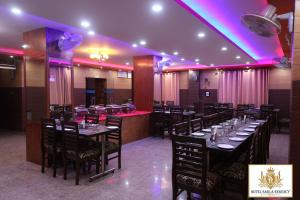 a dining room with tables and chairs and purple lighting at Hotel Sarla Regency in Kulu