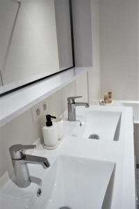 een witte badkamer met een wastafel en een spiegel bij Luxury 2 Bedroom - Antwerp City Centre in Antwerpen