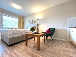 een slaapkamer met een bed, een tafel en een stoel bij Ferienwohnung Mare Nostrum 6 in Westerland