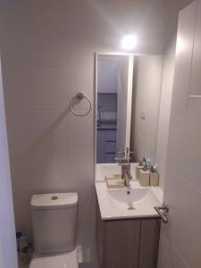 een witte badkamer met een toilet en een wastafel bij Departamento Centro Plaza 404 in Pitrufquén