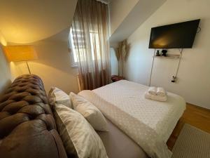 a bedroom with a bed with two towels on it at Charme apartman in Kruševac