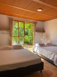 2 camas en una habitación con ventana en Cabaña Compartida en Calabazo - Celestial Villa Tayrona, en Santa Marta