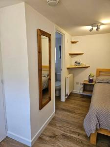 una camera da letto con specchio e letto di The Hayloft, Bannsvale Farm a Truro Altre 25 foto