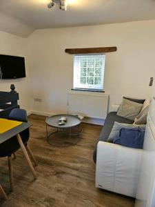 un soggiorno con un divano bianco e un tavolo di The Hayloft, Bannsvale Farm a Truro