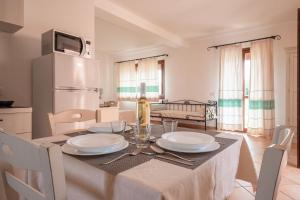 - une cuisine avec une table et une bouteille de vin dans l'établissement Résidence Pierre & Vacances Vignola Mare, à Vignola Mare