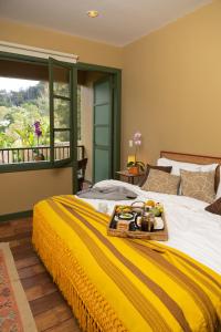 a bedroom with a bed with a tray of food on it at Sazagua Cocora Reserva Natural in Salento