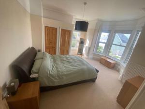 a bedroom with a bed and a couch and windows at Dog friendly home close to the beach and the town in Exmouth