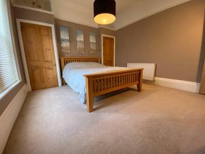 a bedroom with a wooden bed and a wooden door at Dog friendly home close to the beach and the town in Exmouth