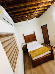 a bedroom with a bed and a wooden ceiling at Happy Land in Shoranūr