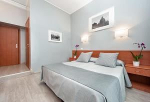 una camera da letto con un grande letto con due cuscini di Hotel Reyes a Roma