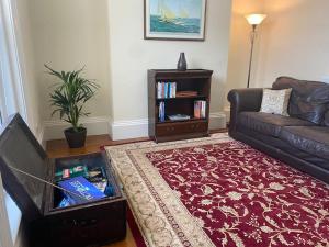a living room with a couch and a book shelf at Dog friendly home close to the beach and the town in Exmouth
