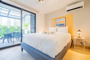 a bedroom with a large bed and a balcony at San Francisco by Wynwood House in Panama City