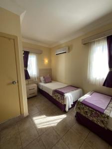 a bedroom with two beds and a window at Canna Garden Hotel - Adult Only in Gümbet +85 photos