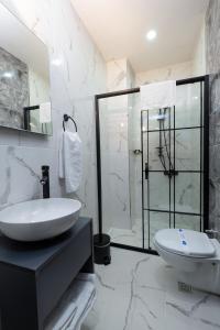 a white bathroom with a sink and a shower at FLY POINT AIRPORT HOTEL in Arnavutköy