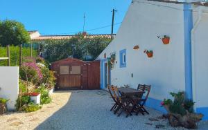 a patio with a table and chairs in front of a house at Casa do Brejão 1 bedroom cottage in Odemira