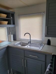 Porchfield的住宿－Thorness Bay，带水槽的厨房台面和窗户