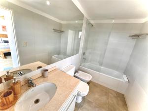 a bathroom with a sink and a toilet and a tub at Apartamento centrico con vistas panoramicas Puerto Iguazu in Puerto Iguazú +22 photos
