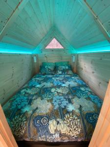 Cama en habitación con techo azul en Le Tiki de Coucou, en Foncine-le-Haut