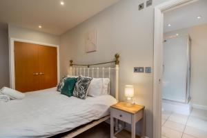 um quarto com uma cama e uma mesa com um candeeiro em Spacious Penthouse - Sleeps 6, Ideal for Contractors, Families & Business Travellers - Free Parking em Watford