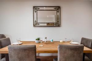 uma mesa de jantar com um espelho na parede em Spacious Penthouse - Sleeps 6, Ideal for Contractors, Families & Business Travellers - Free Parking em Watford