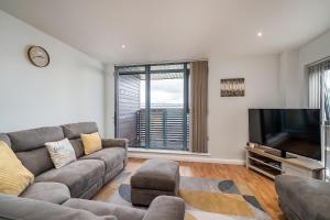 a living room with a couch and a flat screen tv at Spacious Penthouse - Sleeps 6, Ideal for Contractors, Families & Business Travellers - Free Parking in Watford