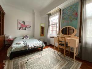 a bedroom with a bed and a desk and a mirror at Habitación Céntrica in A Coruña