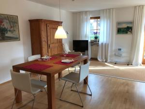 ein Esszimmer mit einem Holztisch und weißen Stühlen in der Unterkunft Ferienwohnung Vera in Lindau-Bodolz