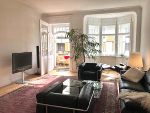 a living room with a couch and chairs and a tv at Ferienwohnung am Segelhafen - Altstadtperle direkt am Segelhafen in Lindau