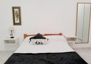 Un dormitorio con una cama blanca con un cartel. en Hermoso Apart Barrio Sur en San Miguel de Tucumán