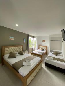 a bedroom with two beds and a large window at HOTEL ARRECIFE in Santa Veronica