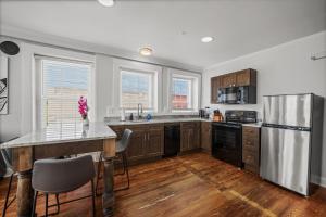 a kitchen with wooden floors and a stainless steel refrigerator at Stylish Loft Steps Away from Main Street in Conway