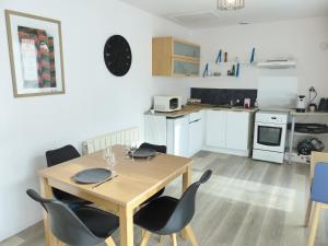 a kitchen and dining room with a wooden table and chairs at LA PETITE MAISON TAHET, 2 pers avec terrasse in Basse-Indre