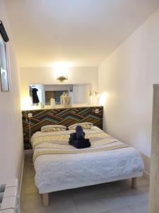 a bedroom with a bed with a hat on it at LA PETITE MAISON TAHET, 2 pers avec terrasse in Basse-Indre