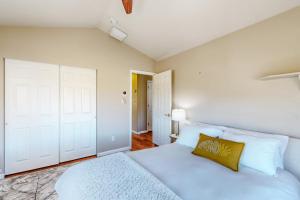 a bedroom with a white bed with a yellow pillow at Casa Rimrock in Grand Junction