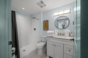 a bathroom with a toilet and a sink and a mirror at Historic Elegance Loft in Downtown Conway in Conway