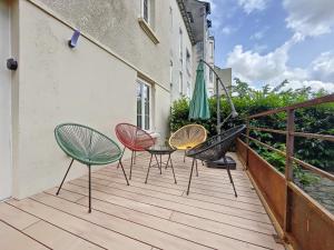 een terras met vier stoelen en een tafel en een paraplu bij L'Oustal Amans Rodat in Rodez