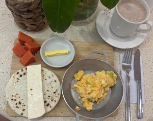 einen Tisch mit einem Teller Essen und einer Käseplatte in der Unterkunft Hotel Centro Monteria in Montería