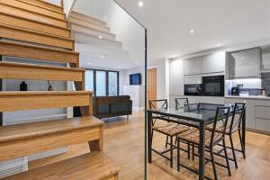 a kitchen and dining room with a glass table and chairs at Stunning 2 Bed basement flat in Hammersmith in London