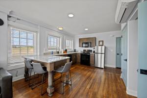 a kitchen with a table and chairs and a refrigerator at Discover Conway Trendy Downtown Loft in Conway