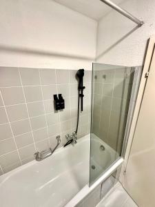 La salle de bains est pourvue d'une douche et d'une baignoire avec un appareil photo. dans l'établissement Ferienwohnung am Bregenzer Hafen, à Bregenz