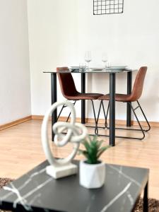 une table à manger noire avec des chaises et une plante dans l'établissement Ferienwohnung am Bregenzer Hafen, à Bregenz